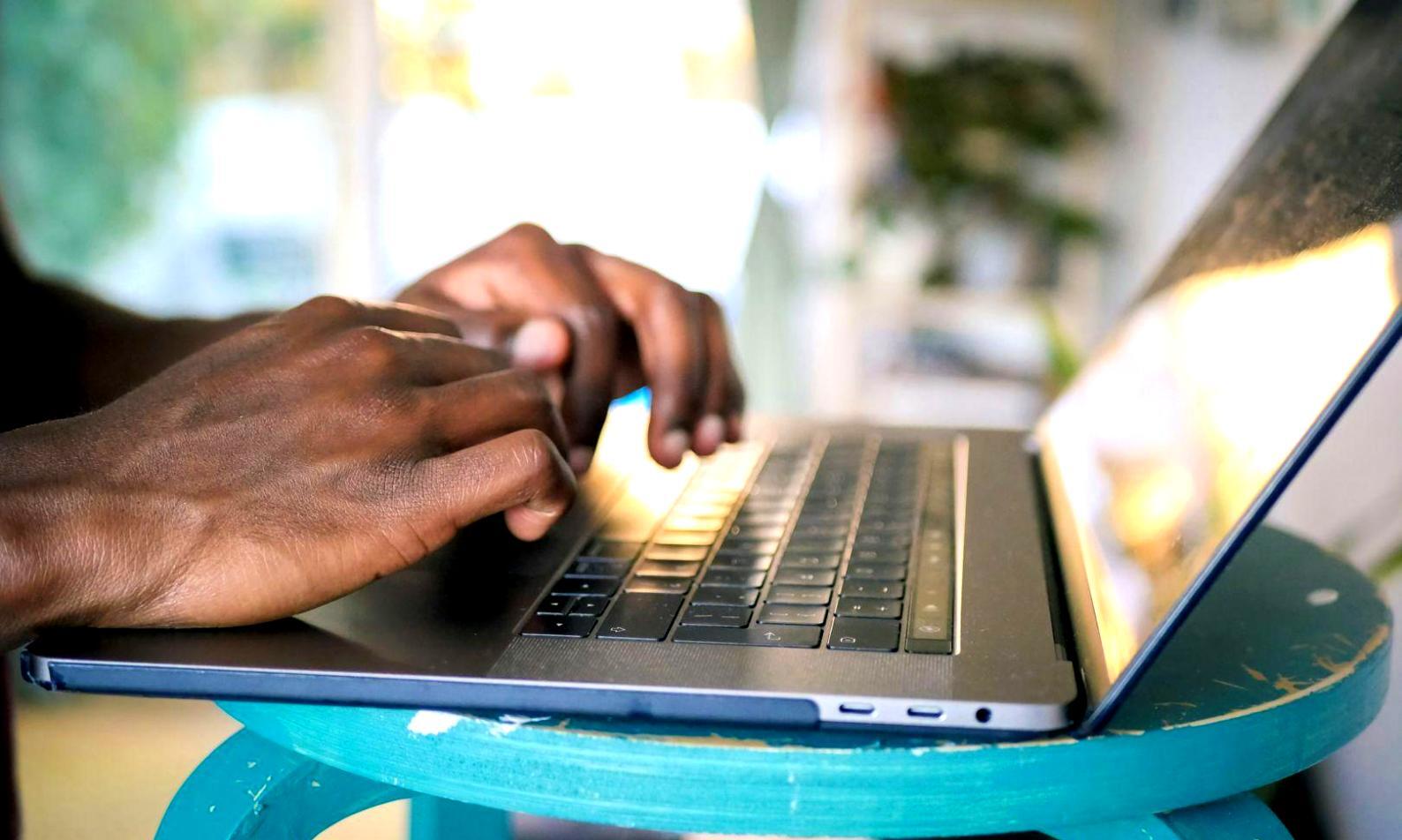 Estudiante analizando gráficos financieros en computadora con múltiples pantallas mostrando datos de mercado
